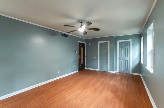 a view of a big room with wooden floor and a ceiling fan