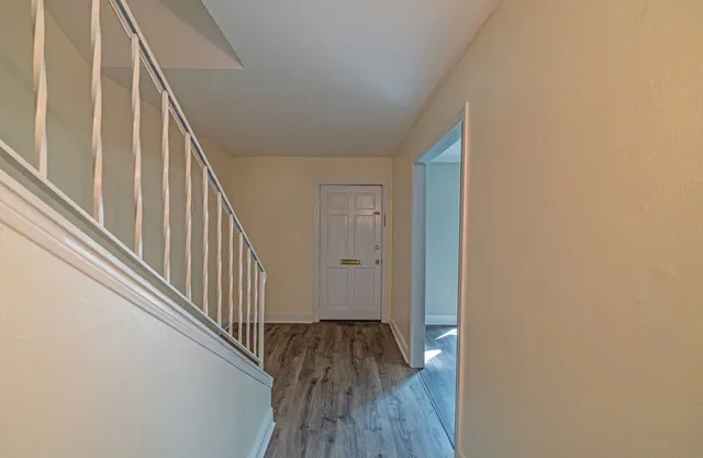 a view of a hallway with wooden floor and staircase