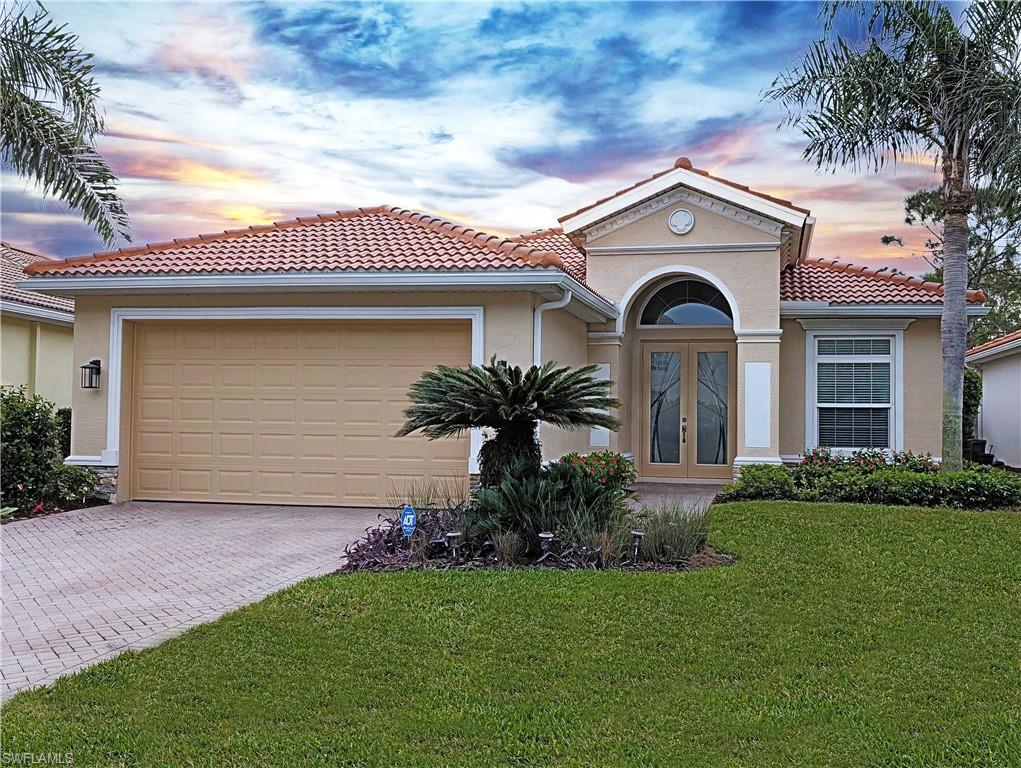 5758 Lago Villaggio Way Naples, FL 34104 - Photo 1 of 42 Mediterranean home with a yard, glass French doors, a garage, and stucco siding