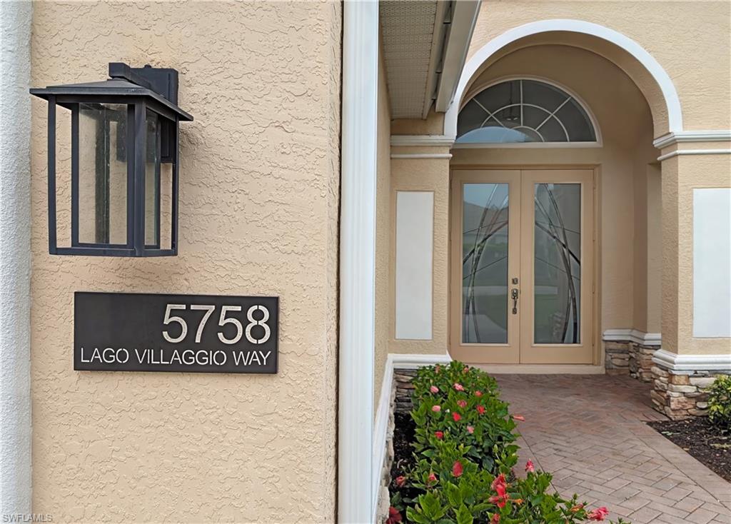 5758 Lago Villaggio Way Naples, FL 34104 - Photo 2 of 42 Doorway to property featuring stucco siding, stone siding, and french doors