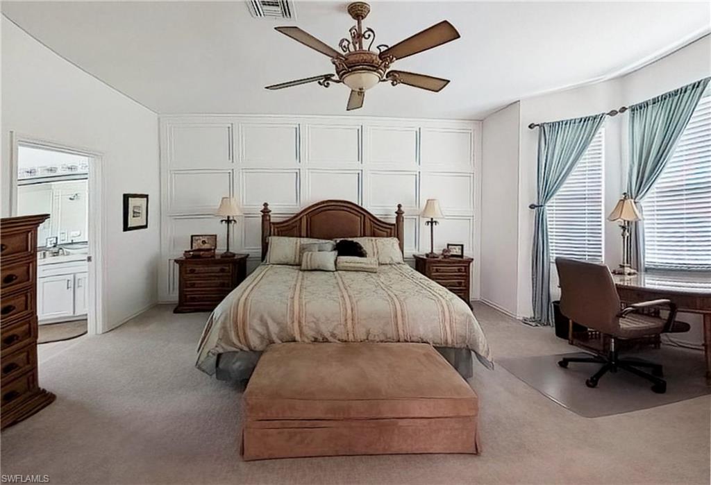 5758 Lago Villaggio Way Naples, FL 34104 - Photo 25 of 42 Carpeted bedroom with a ceiling fan, an office area, and a decorative wall