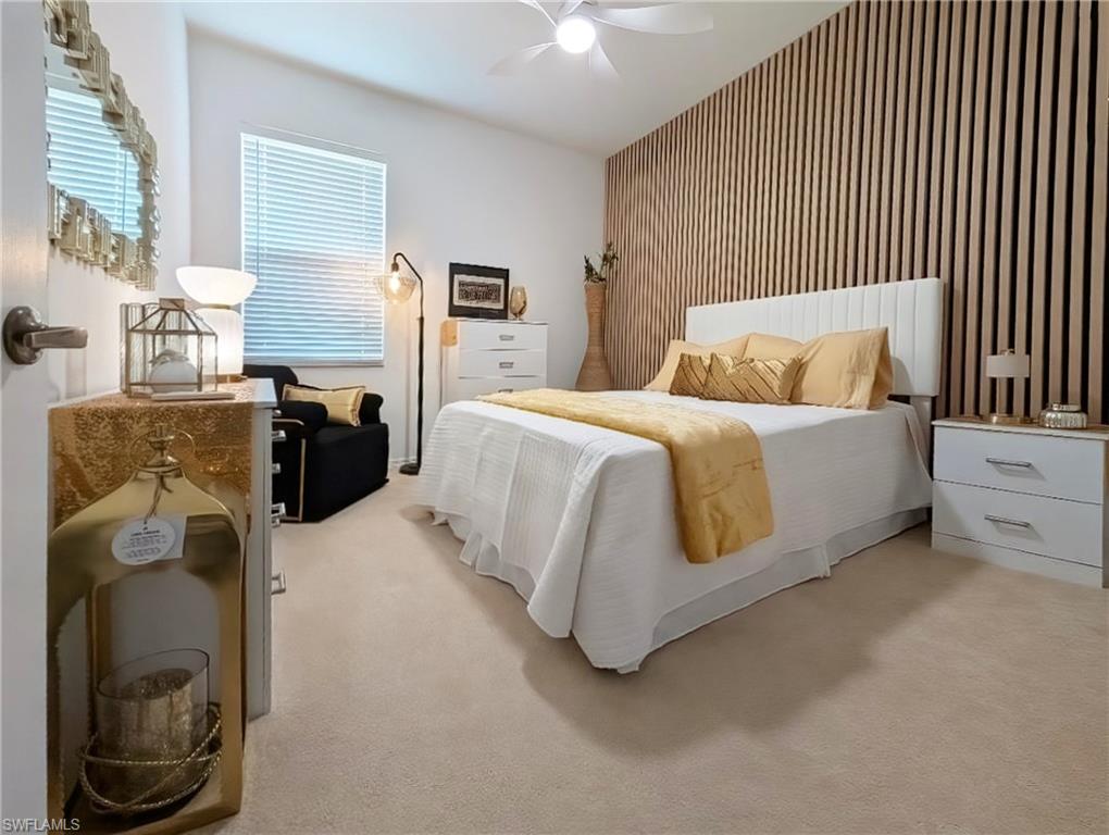 5758 Lago Villaggio Way Naples, FL 34104 - Photo 32 of 42 Bedroom with an accent wall, light colored carpet, and ceiling fan