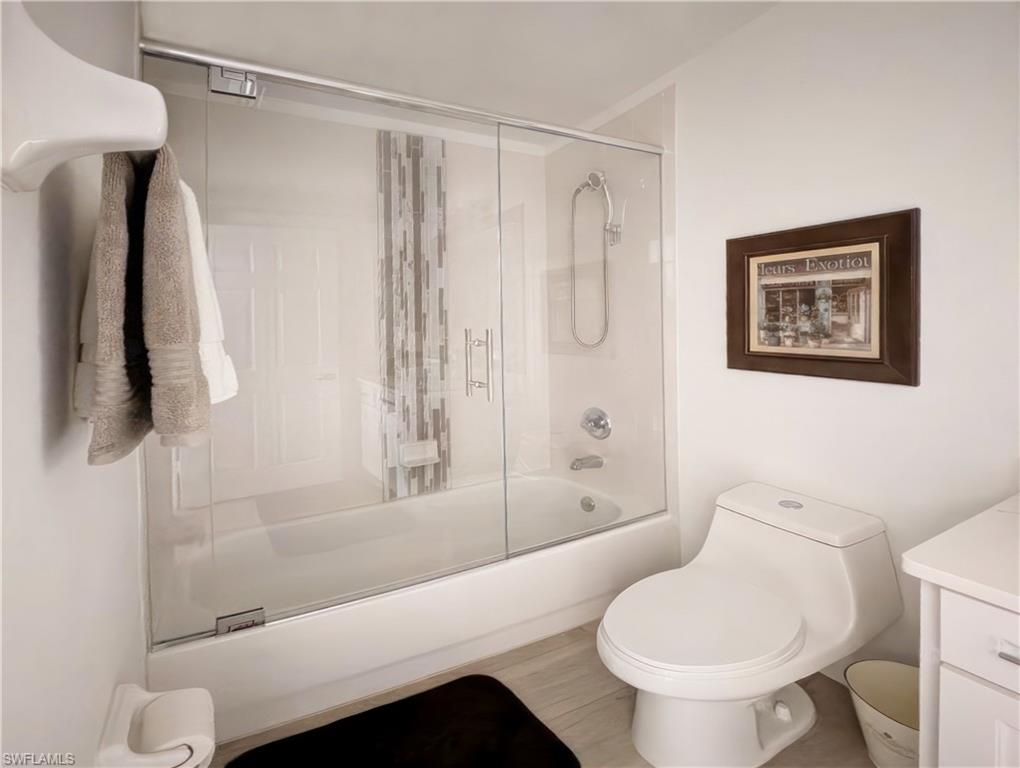 5758 Lago Villaggio Way Naples, FL 34104 - Photo 37 of 42 Full bathroom with vanity, bath / shower combo with glass door, and toilet