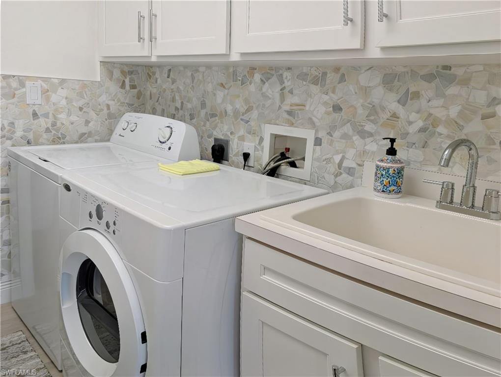 5758 Lago Villaggio Way Naples, FL 34104 - Photo 39 of 42 Laundry area featuring cabinets, washing machine and dryer, and sink