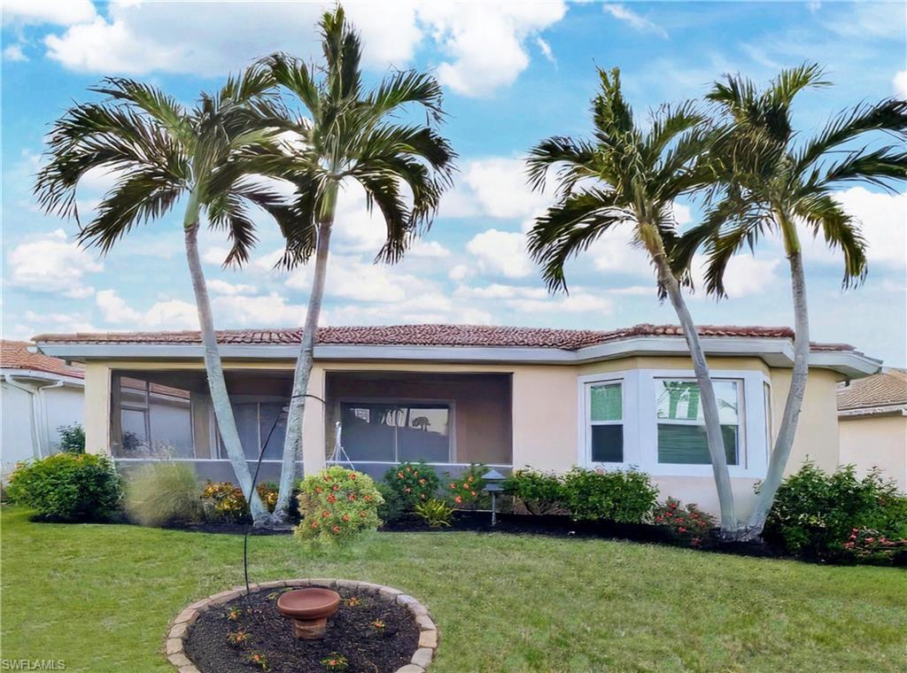 5758 Lago Villaggio Way Naples, FL 34104 - Photo 6 of 42 Rear view of house featuring a rear lawn