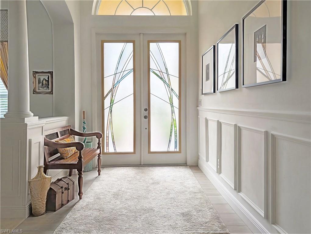 5758 Lago Villaggio Way Naples, FL 34104 - Photo 8 of 42 Entryway featuring a decorative wall, french doors, and a wainscoted wall
