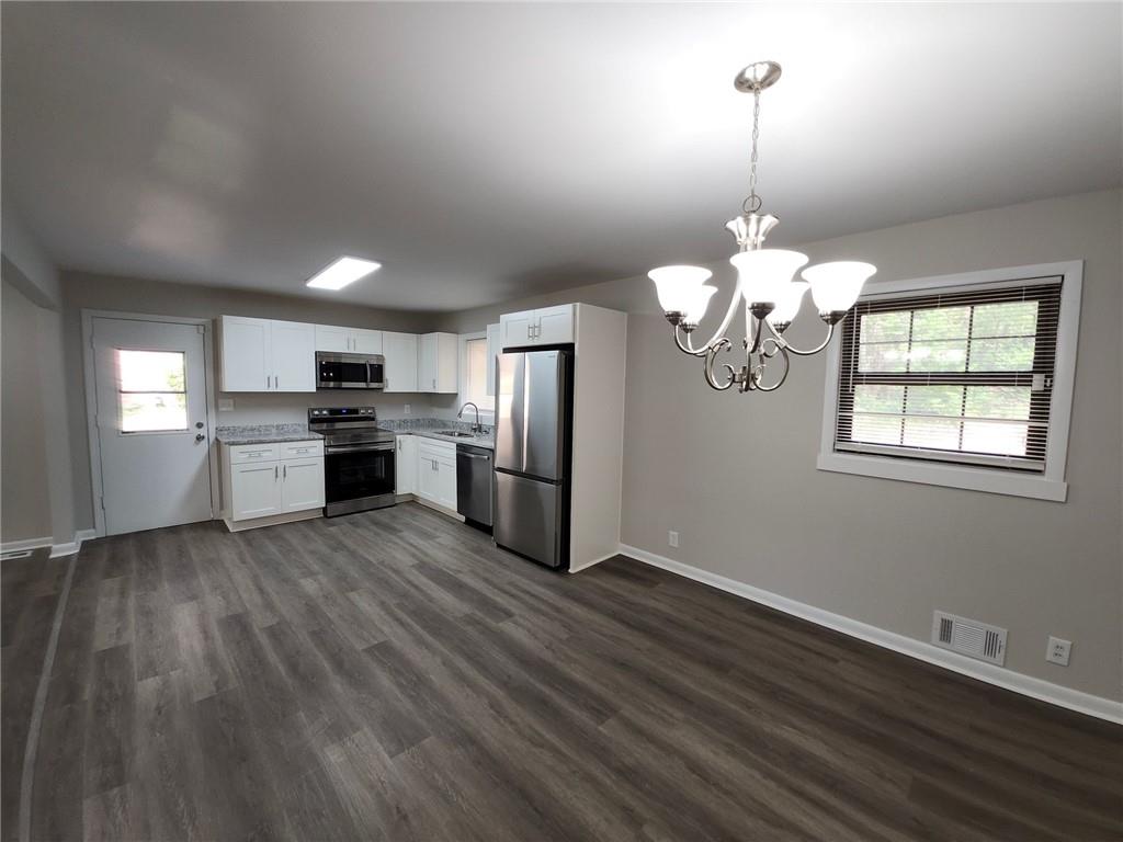 5370 Longmeadow Lane Atlanta, GA 30349 - Photo 4 of 13 a view of a kitchen with stove and wooden floor