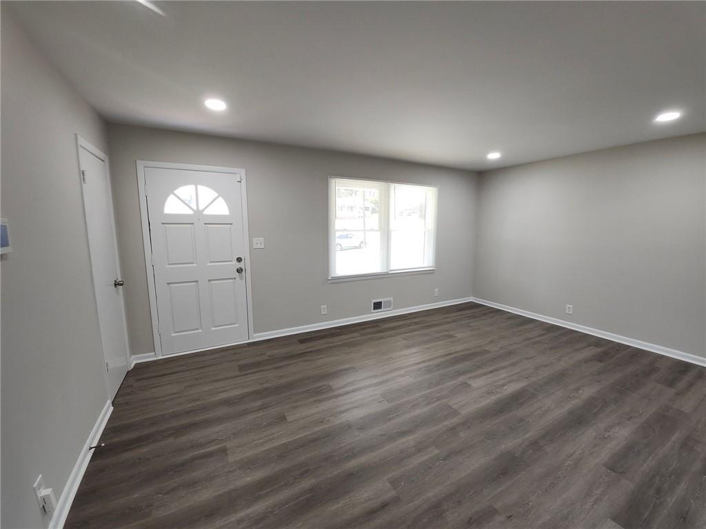5370 Longmeadow Lane Atlanta, GA 30349 - Photo 6 of 13 an empty room with wooden floor and windows