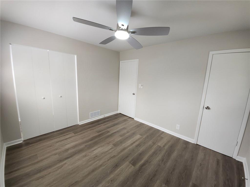 5370 Longmeadow Lane Atlanta, GA 30349 - Photo 10 of 13 an empty room with wooden floor and fan