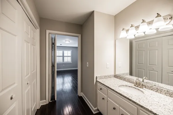 a bathroom with a granite countertop sink and a mirror