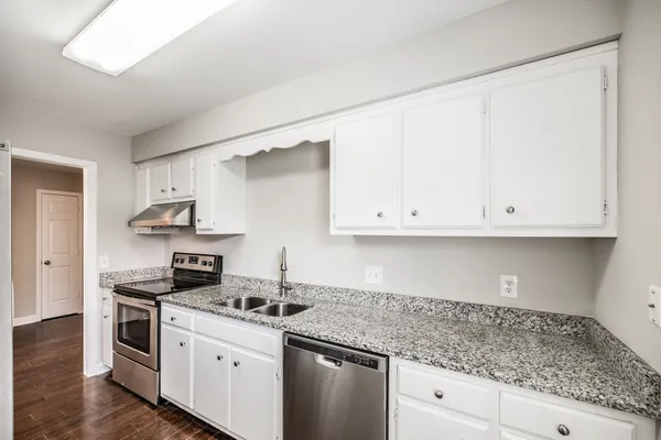 a kitchen with stainless steel appliances granite countertop a sink and a stove