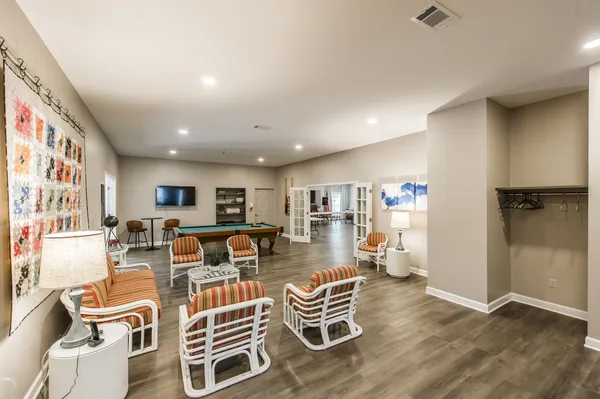 a living room with furniture a flat screen tv and kitchen view