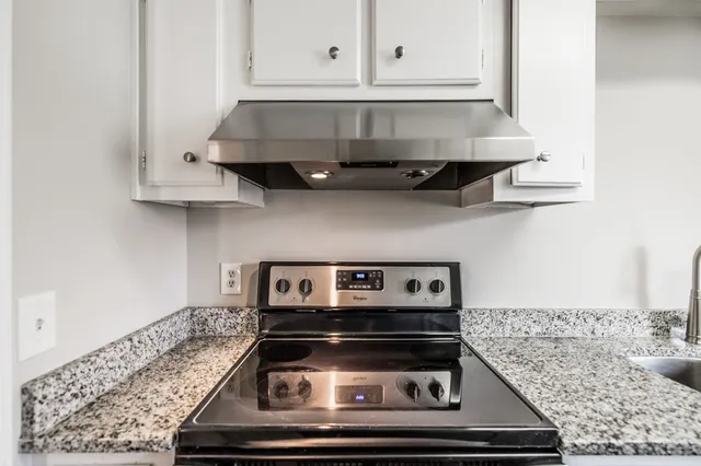 a stove top oven sitting inside of a kitchen