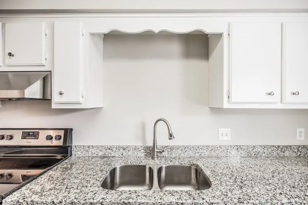 a kitchen with stainless steel appliances granite countertop a sink and a stove