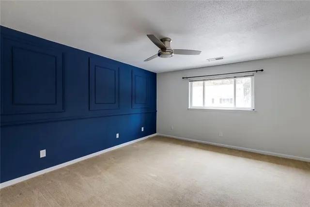 a view of an empty room with a ceiling fan