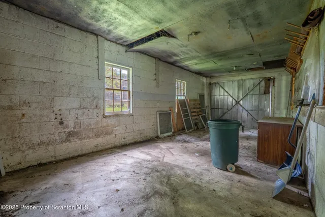 a backyard of a house with plants and large tree