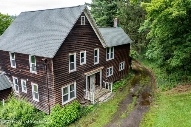 a aerial view of a house with a yard and balcony