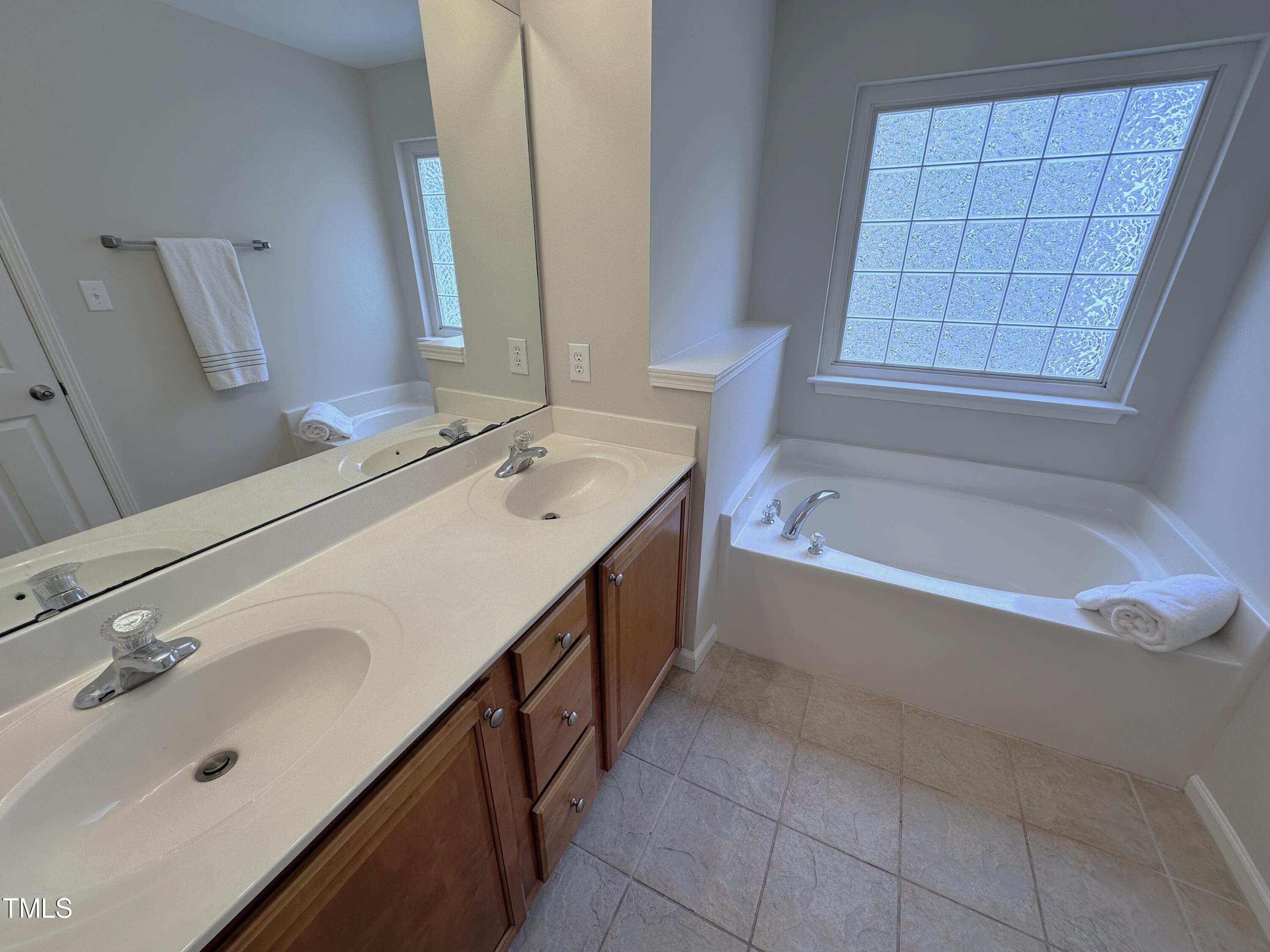 7608 Morrell Lane Durham, NC 27713 - Photo 21 of 34 a spacious bathroom with a bathtub sink and mirror