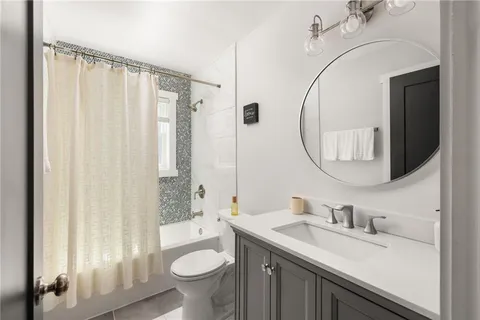 a bathroom with a granite countertop sink mirror vanity and toilet