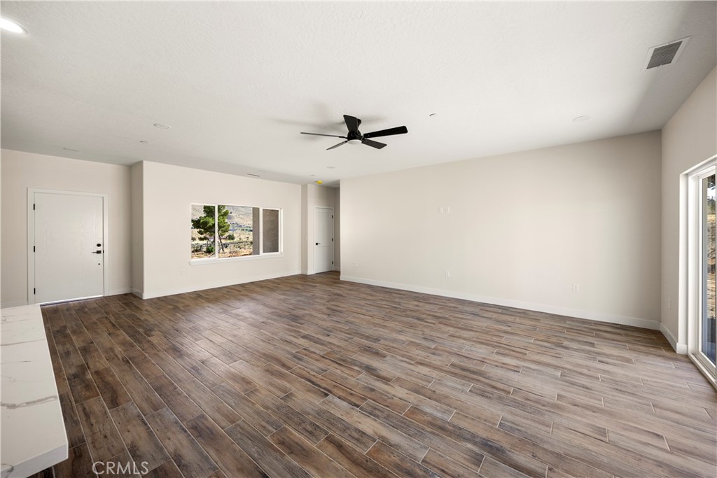 22324 Rancho Street Apple Valley, CA 92308 - Photo 15 of 47 an empty room with a ceiling fan and wooden floor