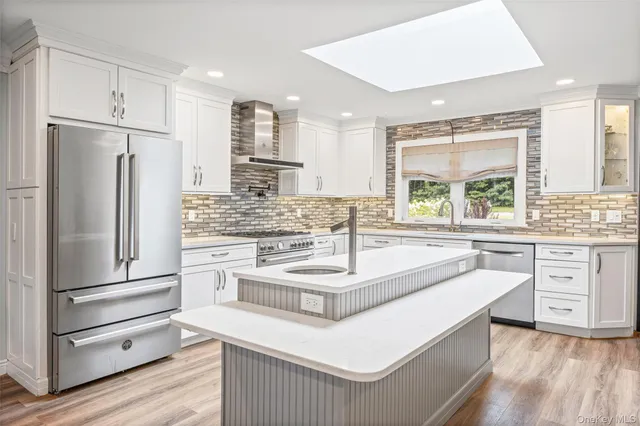a kitchen with kitchen island white cabinets and refrigerator