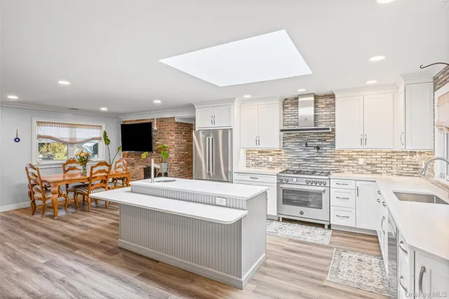 a large kitchen with stainless steel appliances kitchen island granite countertop a stove and a sink