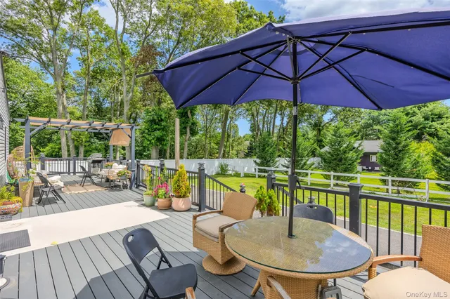 a view of a patio with couches table and chairs under an umbrella