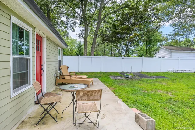 a view of a chair and table in backyard of the house