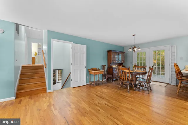 a dining room with furniture a chandelier and wooden floor