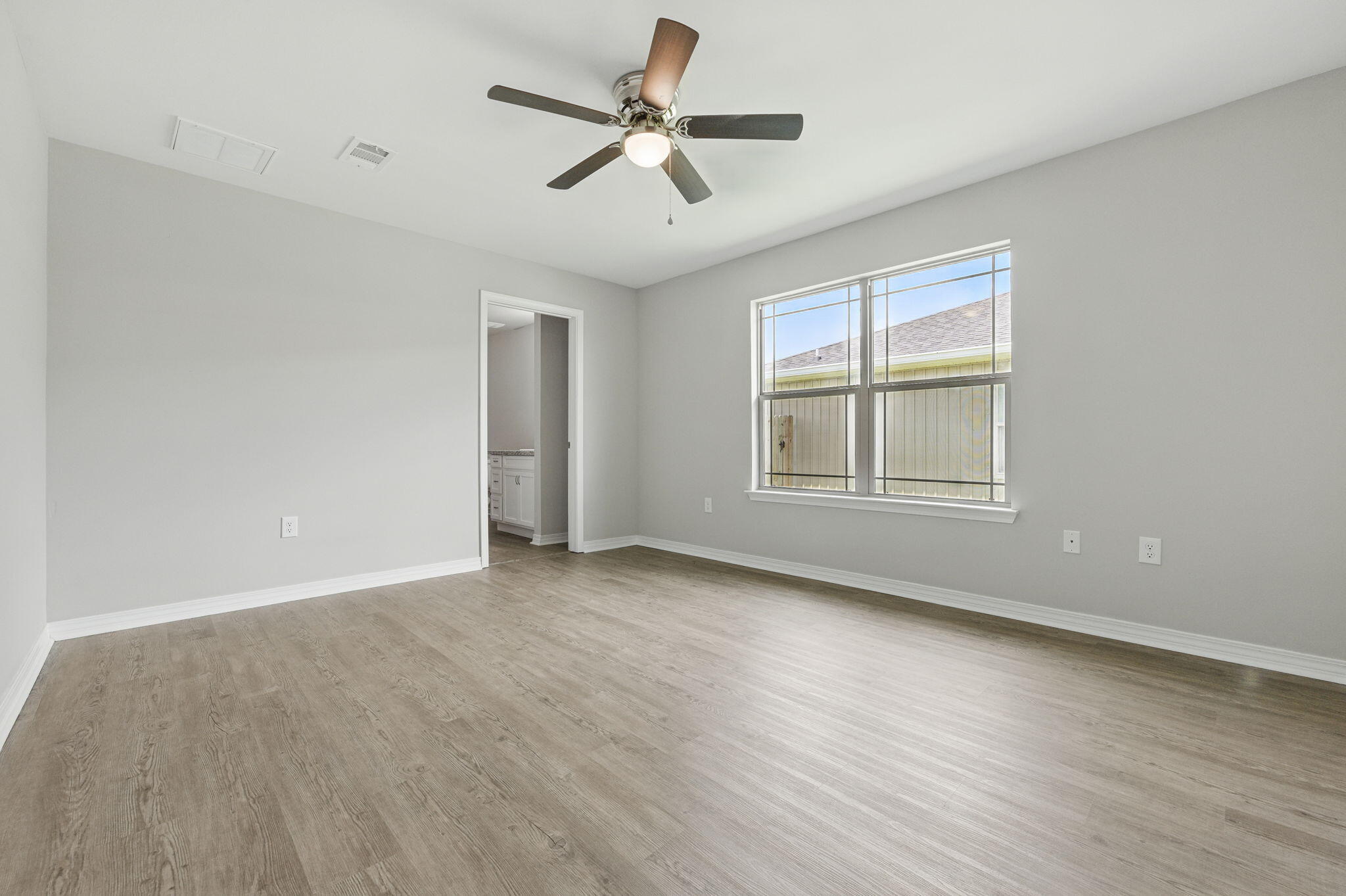 3541 Godwin Road Jay, FL 32565 - Photo 10 of 28 a view of an empty room with a window and wooden floor