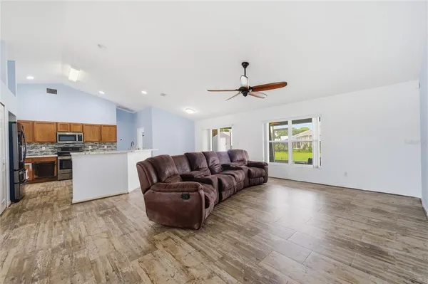 a living room with furniture and kitchen view