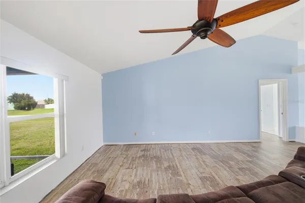 a view of a room with wooden floor and a ceiling fan