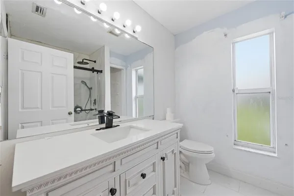 a bathroom with a sink a toilet and a mirror
