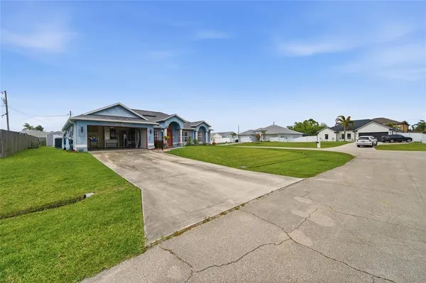 a view of house with yard and car parked