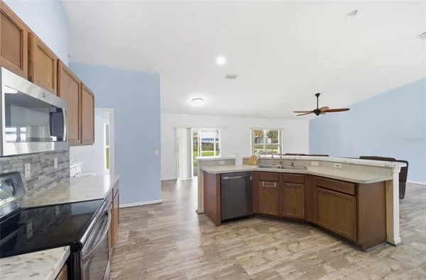 a large kitchen with stainless steel appliances granite countertop a sink and dishwasher a stove with wooden cabinets