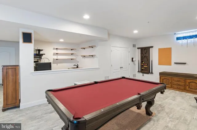 a room with furniture pool table and window
