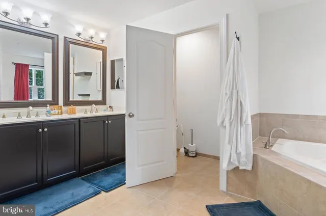a bathroom with a tub sink and mirror