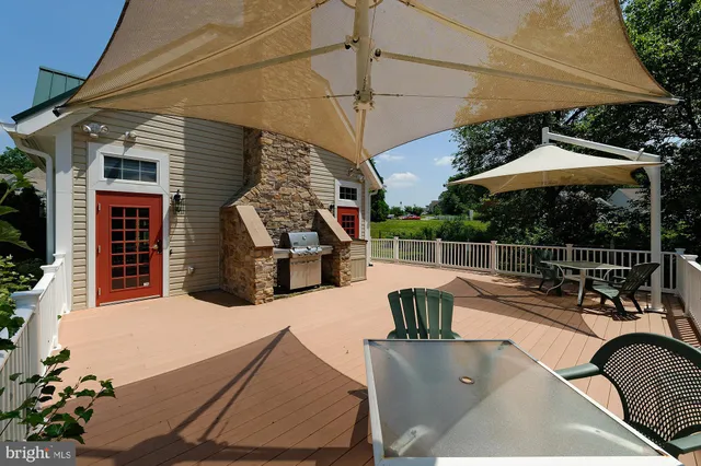a view of a patio with couches table and chairs under an umbrella