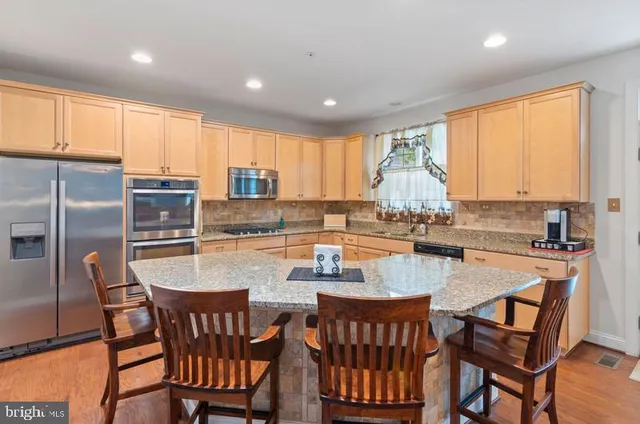 a kitchen with granite countertop a dining table chairs counter space cabinets and appliances