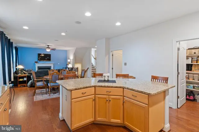 a open kitchen with stainless steel appliances granite countertop a refrigerator and a view of living room