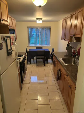 a kitchen with granite countertop a stove a sink and a refrigerator