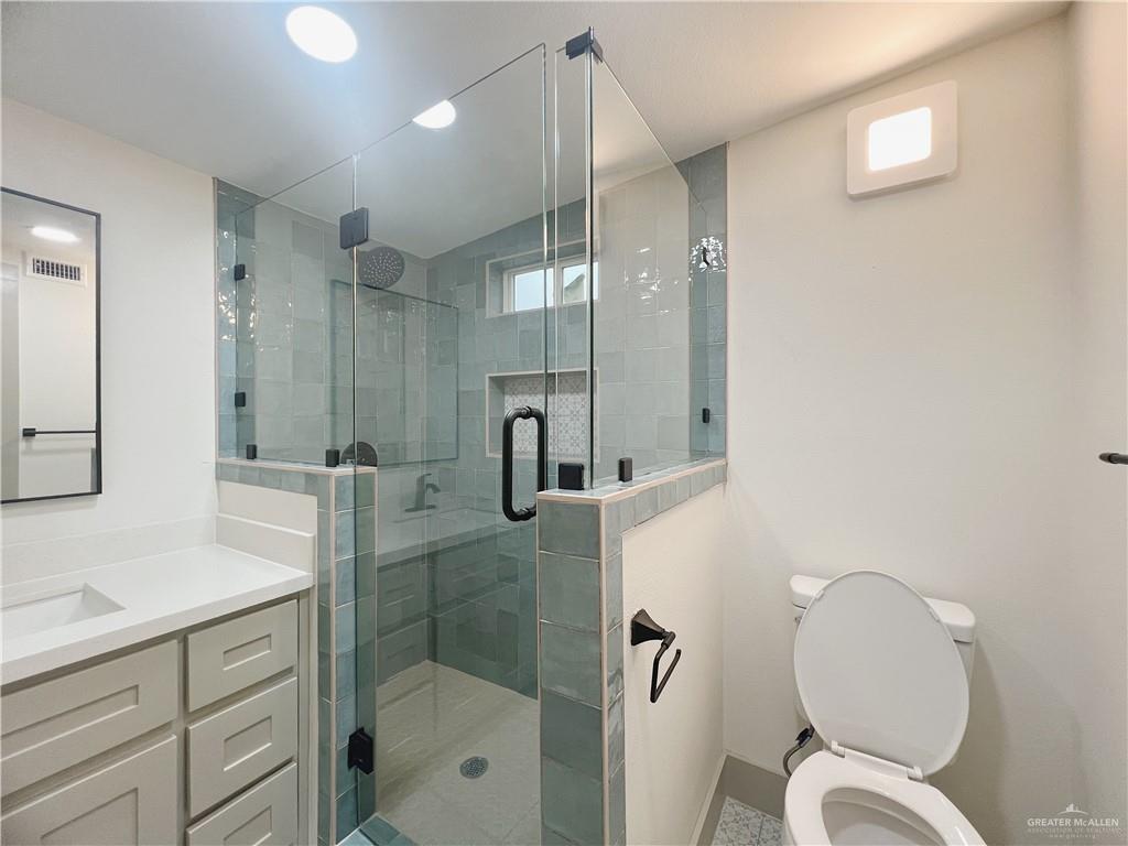 604 North 11th Street McAllen, TX 78501 - Photo 11 of 20 a bathroom with a shower sink mirror and toilet