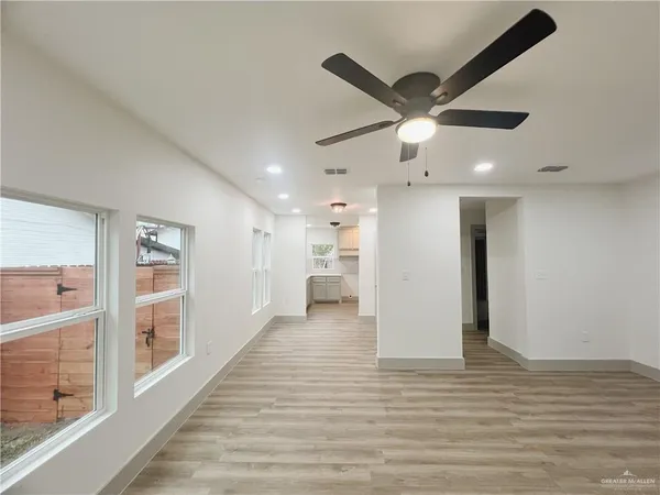 a view of a livingroom with a ceiling fan and wooden floor