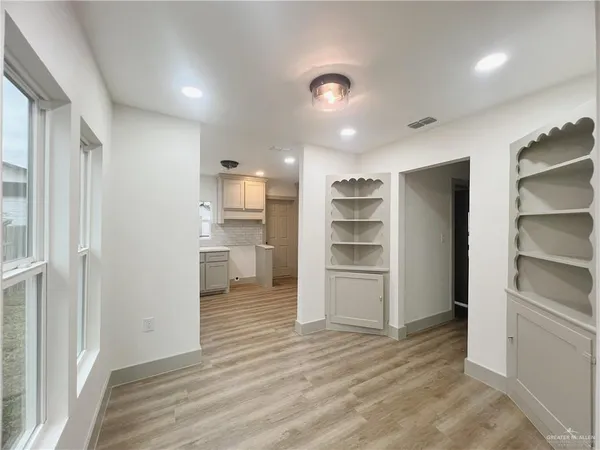 a view of a kitchen with refrigerator and an empty room