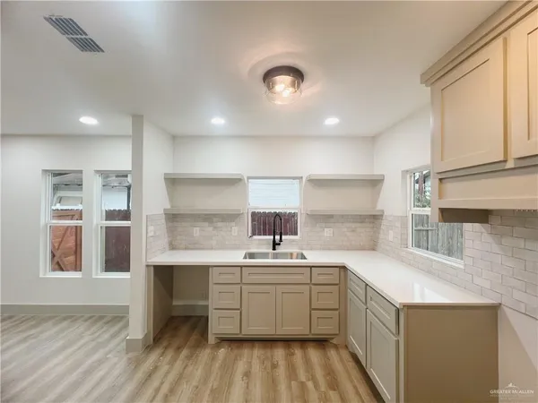 a kitchen with a sink window and cabinets