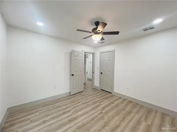 a view of room with wooden floor and ceiling fan