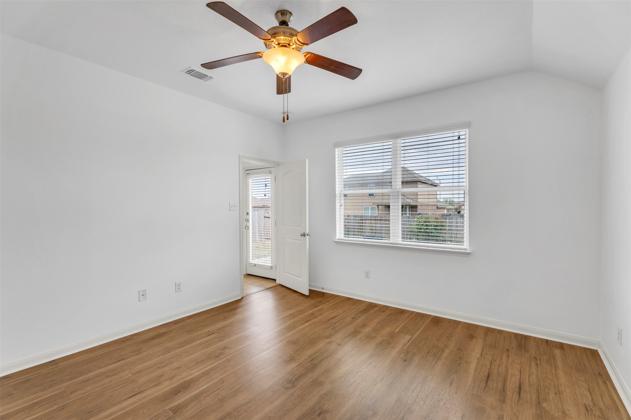 13213 Clara Martin Road Manor, TX 78653 - Photo 21 of 38 Empty room featuring wood finished floors, a ceiling fan, and vaulted ceiling