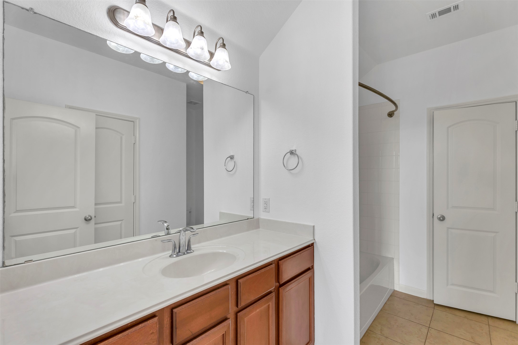 13213 Clara Martin Road Manor, TX 78653 - Photo 23 of 38 Bathroom featuring vanity, light tile patterned floors, and bathing tub / shower combination