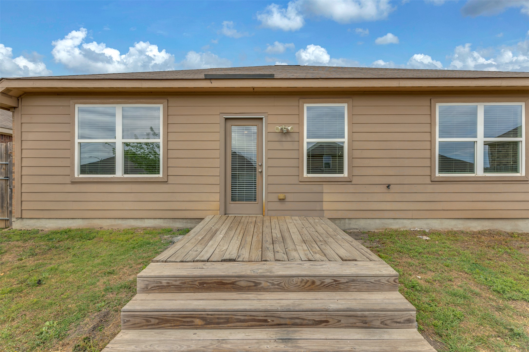 13213 Clara Martin Road Manor, TX 78653 - Photo 31 of 38 Rear view of house featuring a yard and a wooden deck