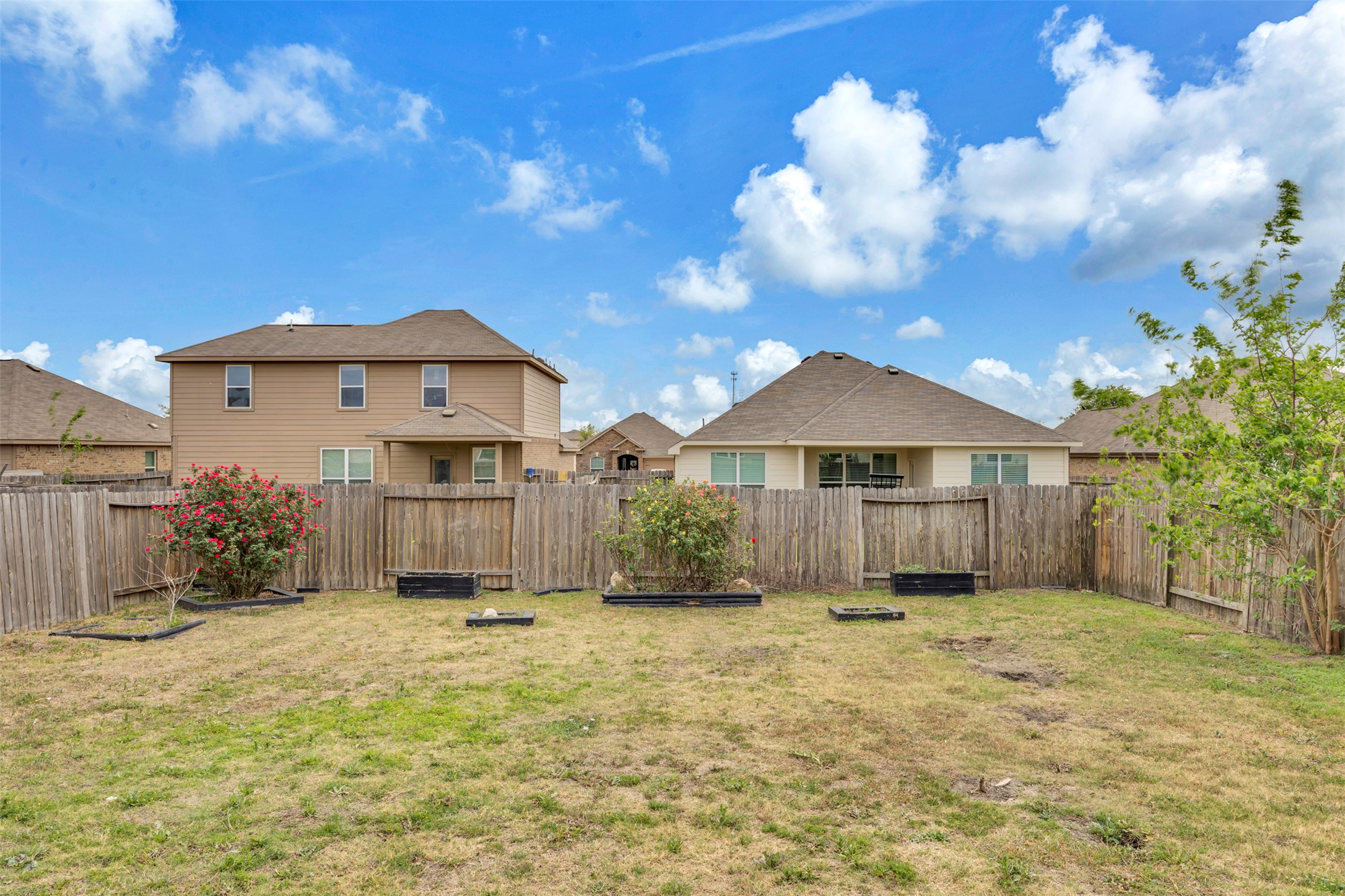13213 Clara Martin Road Manor, TX 78653 - Photo 32 of 38 Fenced backyard with a vegetable garden and a residential view